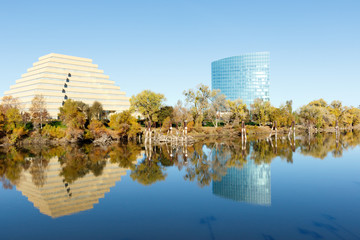 Two buildings reflecting off the water of the Sacramento River, in the capital of California