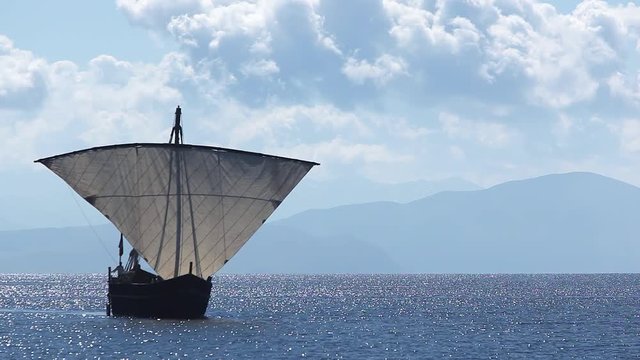 Sailboat floats in the sea or ocean, an old style ship on the water