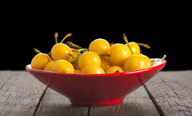 Yellow cherry in red vase