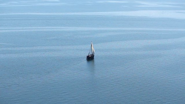 Sailboat floats in the sea or ocean, an old style ship on the water