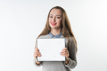 Fototapeta premium Business concept - Young woman with an empty plate or frame isolated on white background. Free Copyspace