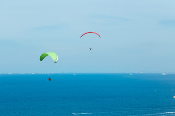 Fototapeta na wymiar Two Paragliding flying through the sea and beautiful sky, Koh Lan Pattaya Thailand