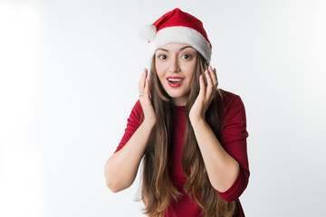 beautiful woman wearing red santa claus hat isolated on white background, copy space. She has shock, surprise emotion on her face. Sales concept