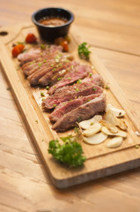 Top view of grilled beef tendeloin steak with spices sauce and garlic on cutting board