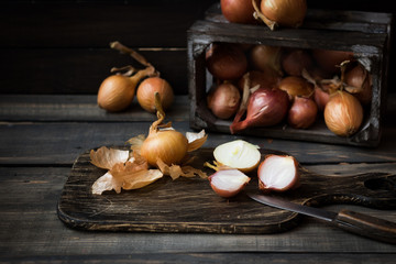 Onion in a wooden box on a dark background