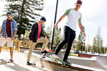 Fototapeta na wymiar Teenage boys skateboarding outdoors