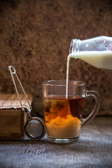 Tea with milk. Hot black tea in a glass mug