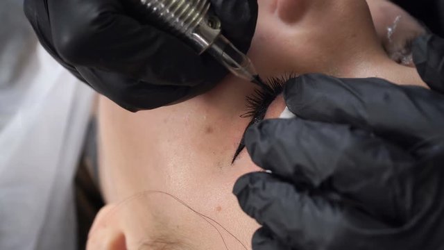 Beautician, specialist of permanent make-up making eyeliner permanent make up