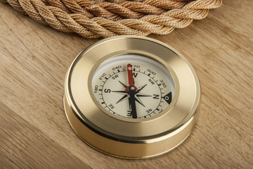 Fototapeta na wymiar rope and compass on a wooden background