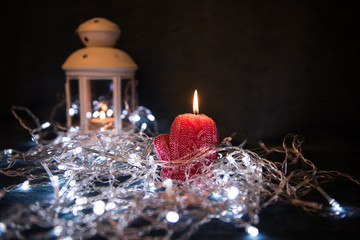 A red candle with Christmas lights in the atmospheric light