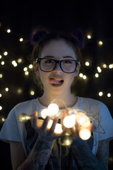 Beautiful young woman smiling and talking garlands of lights 