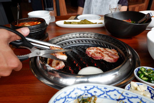Grilling pork Korean barbecue style in restaurant