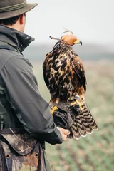 Tuinposter Falconer with hawk on the hand © zorandim75