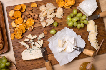 Cheese board. Various types of cheese. Cheese plate with cheeses Parmesan, Brie, Camembert and Roquefort  serving on wooden board.