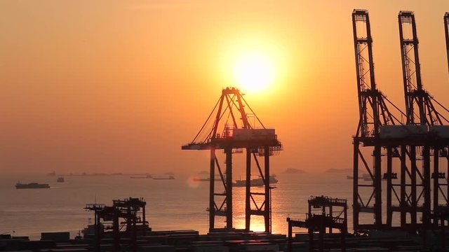 Shanghai Cargo terminal, container ships and lifting cranes at sunset, (Yangshan is one of the world's busiest container port)