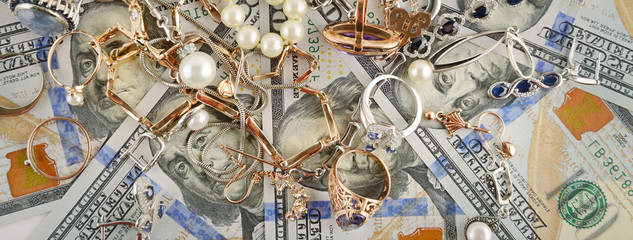 Background of American dollars and jewelry. Flat lay, top view.