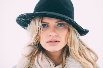 Beautiful winter portrait of young woman in the winter snowy scenery.