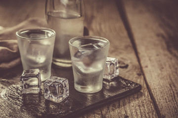 Vodka in shot glasses on rustic wood background