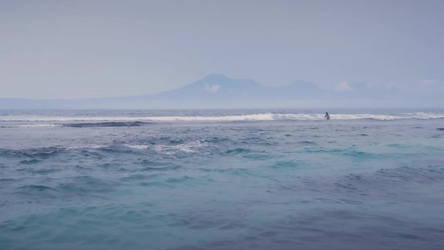 Beautiful Blue Ocean Waves and a mountain at background in Slow Motion