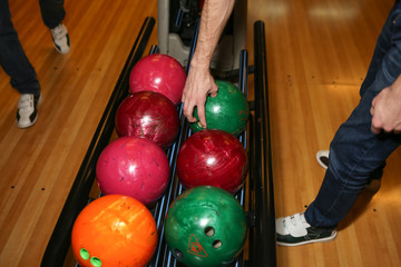 Bowling balls. Bowling alley. Man takes a ball. Vivid colors