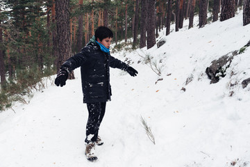 Fototapeta na wymiar Young boy having fun with snow in the mountain