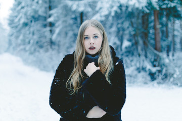 Fototapeta na wymiar Junge blonde Frau in Winterlandschaft