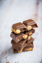 Pile of dark chocolate with nuts on the wooden table. Selective focus. Shallow depth of field.