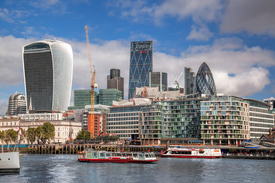 London with modern city architecture against river with boats in England, UK