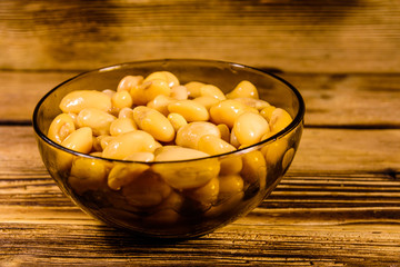 White marinated haricot beans in glass bowl on a wooden table