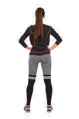 Fototapeta premium Woman Standing Legs Apart In Fitness Outfit. Rear View.