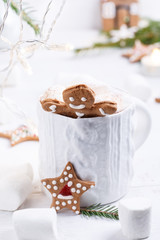 Fototapeta na wymiar Cup of traditional hot chocolate with marshmallows and gingerbread on white table. Christmas drink in New Year decorations.
