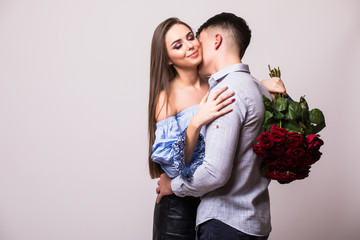 Young couple with roses kissing isolated on white