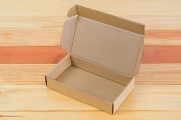 Empty brown cardboard box on wooden table with copy space.