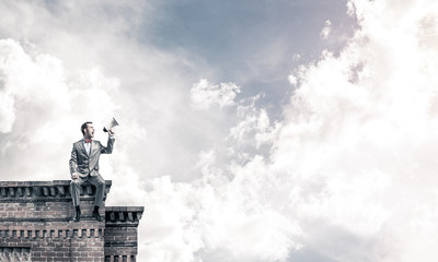 Businessman or manager on building roof announcing something in 
