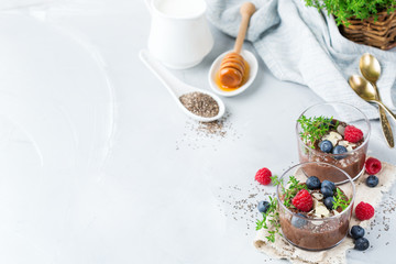 Fototapeta na wymiar Healthy vegan chocolate chia pudding with berries and green thyme