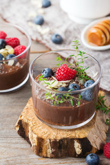 Healthy vegan chocolate chia pudding with berries and green thyme