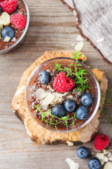 Healthy vegan chocolate chia pudding with berries and green thyme