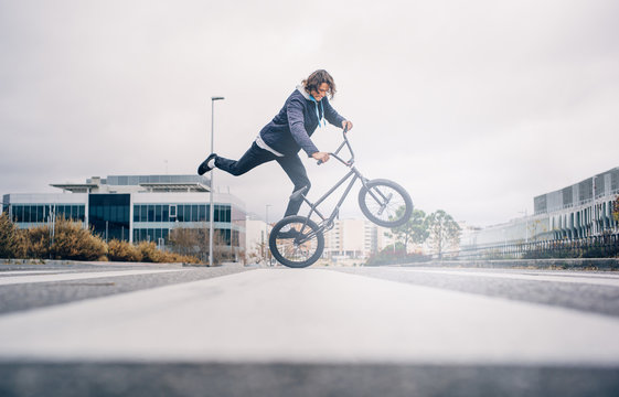 Young man practices with BMX bicycle.