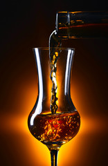 Pouring alcohol drink into a wineglass .