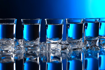 Glasses of vodka with ice .