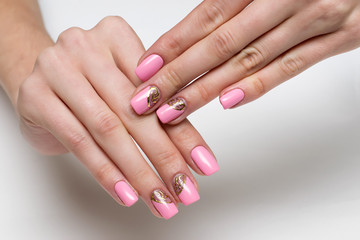 Obraz na płótnie Canvas pink manicure with gold design on long square nails
