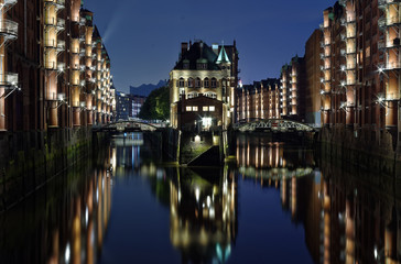 Obraz premium Hamburg Zollkanal mit historischer Speicherstadt im Hintergrund bei Nacht