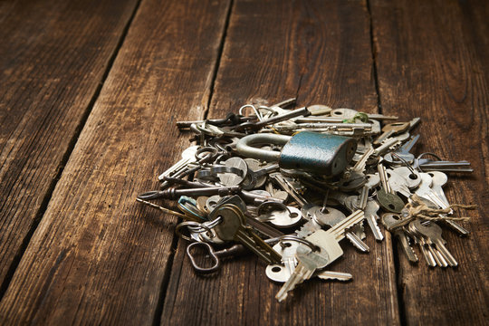 check-lock and group of different keys on wooden background with copy space. Concept of lost keys
