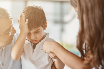 Upset little boy receiving support from his family