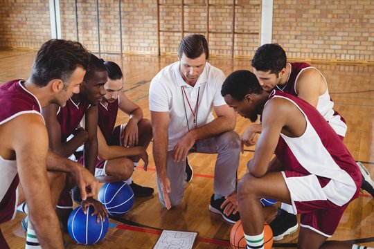 Coach Explaining Game Plan To Basketball Players