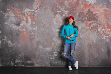 Woman standing full length on loft background, sport, casual style, smiling, copy space