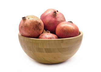 Big round brown bowl full ob ripe whole pomegranates studio shot isolated on white background front view