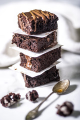 Pieces of chocolate baked brownies in a stacked pile. Gourmet concept.