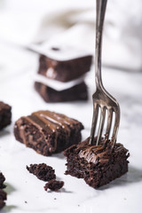 Pieces of chocolate baked brownies in a stacked pile. Gourmet concept.