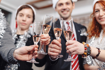 Cropped shot of young business colleagues drinking champagne in 